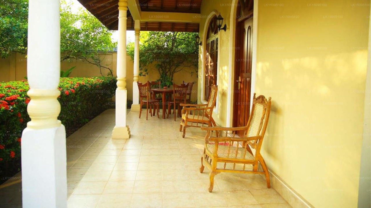 Outdoor patio area with wooden chairs and a table on a sunny day.