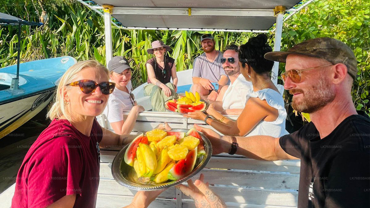 Group of people on a boat with fruit plates, surrounded by greenery